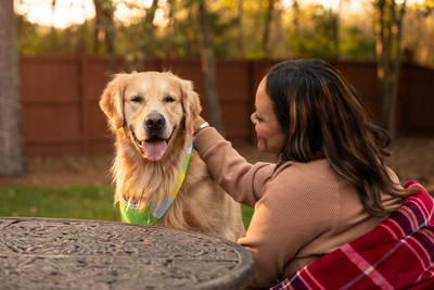 Woman petting her dog outside.